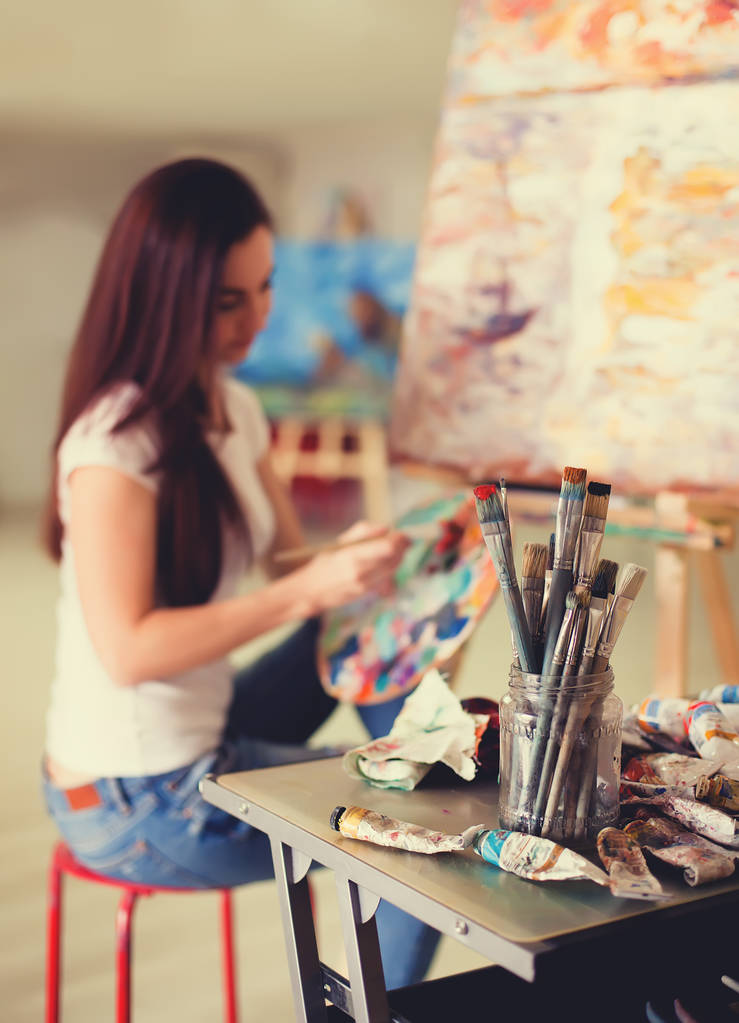 Γυναίκα καλλιτέχνης εργάζεται για ζωγραφική στο Studio. Εικόνα φόντου, επιλεκτική εστίαση σε πρώτο πλάνο - Φωτογραφία, εικόνα