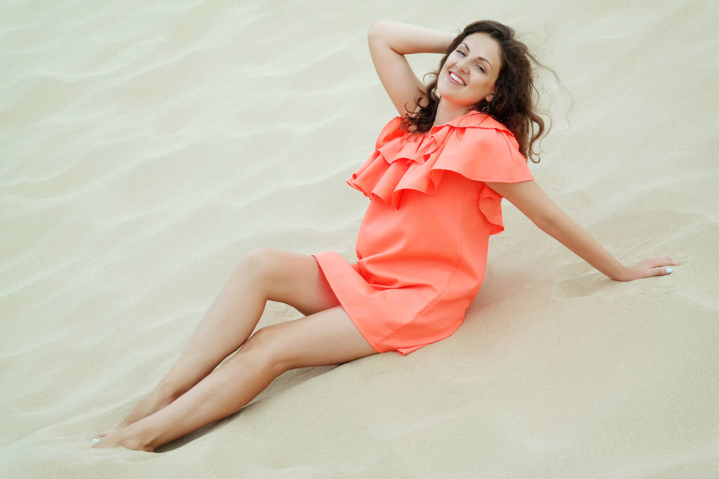 Νεαρή γυναίκα στην πορτοκαλί φόρεμα για την παραλία - Φωτογραφία, εικόνα