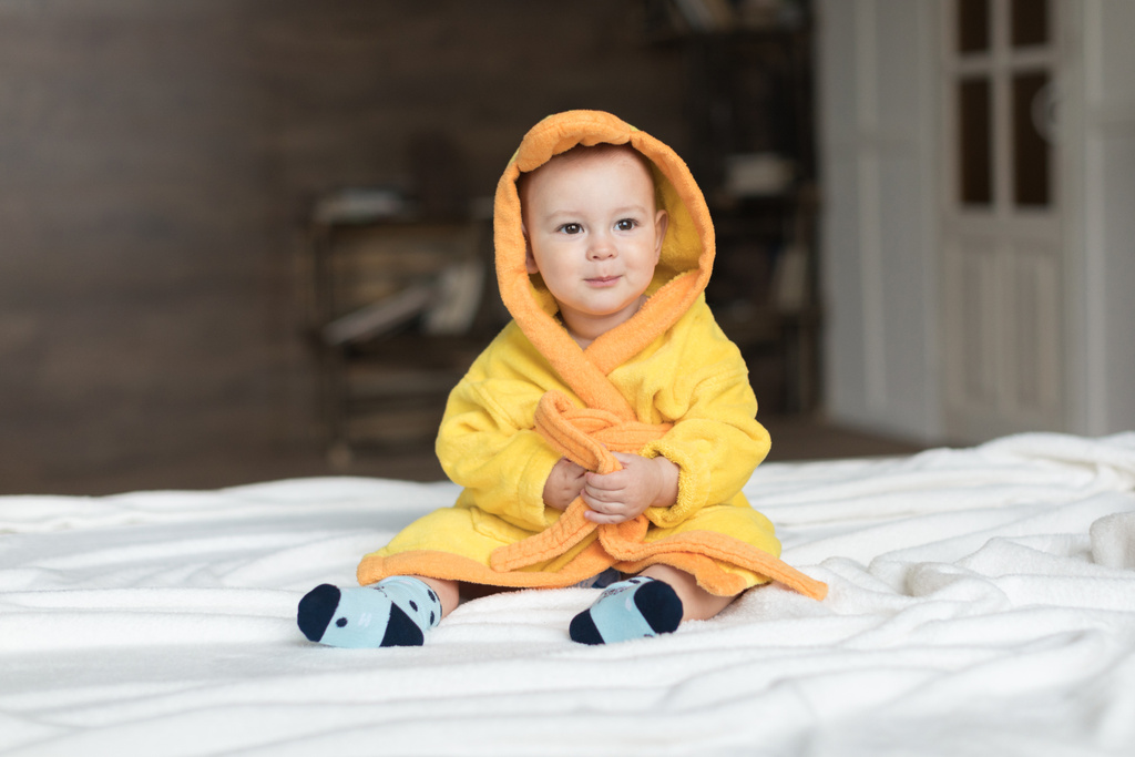 bebé niño en bata amarilla
 - Foto, imagen