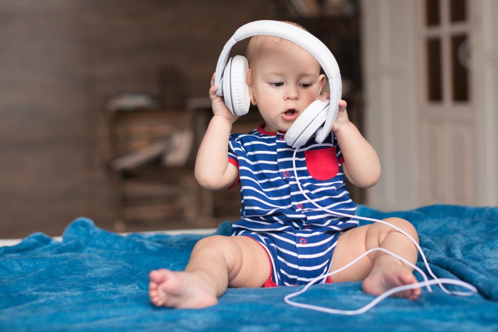 bebé niño con auriculares blancos
 - Foto, imagen