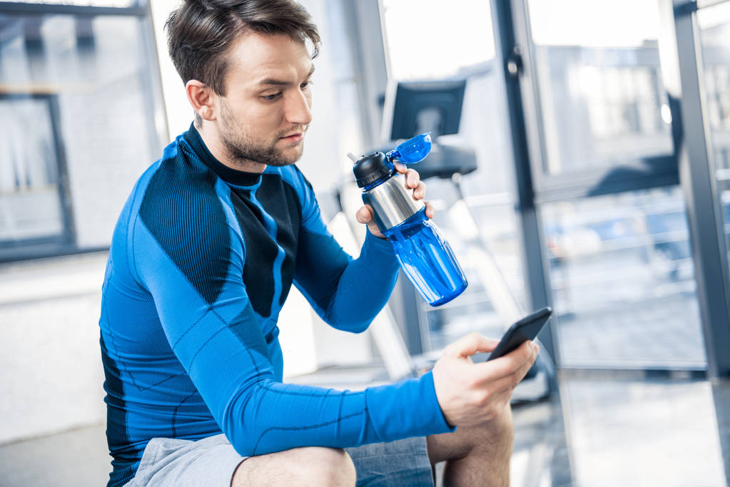 hombre usando smartphone en el gimnasio
 - Foto, imagen