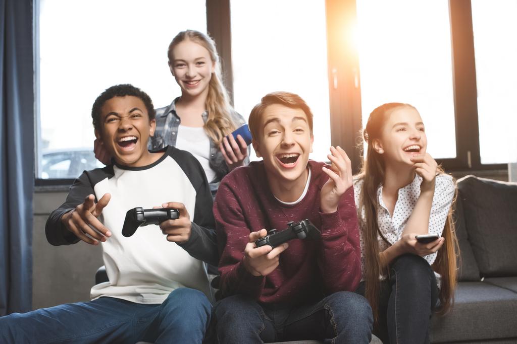 adolescentes multiculturales con joysticks
 - Foto, imagen