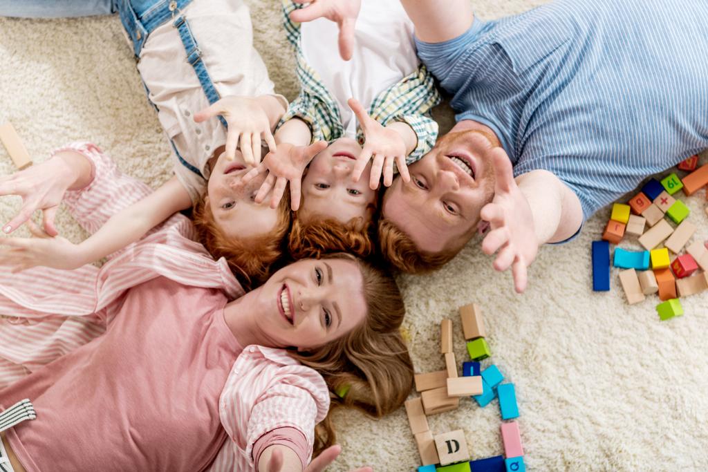 Famille heureuse couchée sur le sol
 - Photo, image