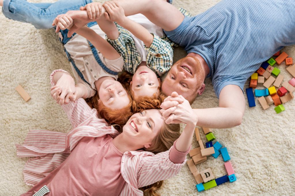 Familia feliz tendida en el suelo
 - Foto, Imagen