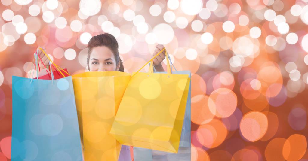 Woman holding shopping bags over bokeh - Photo, Image