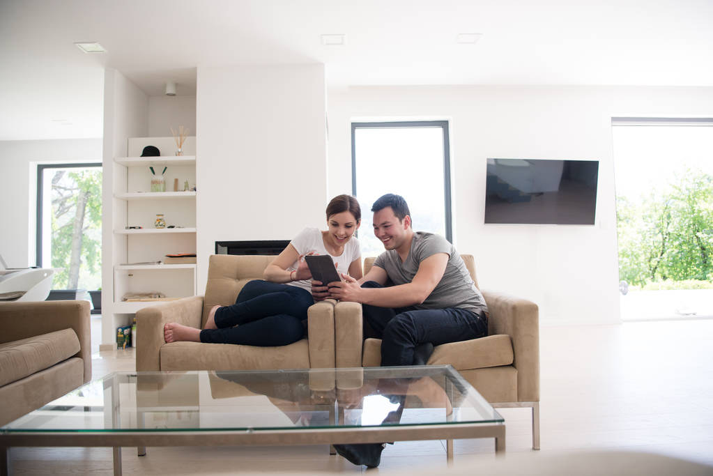 pareja relajante en casa con tabletas
 - Foto, imagen