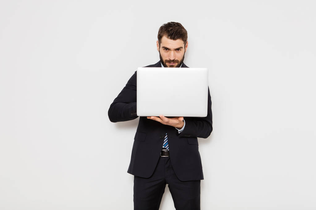 elegante uomo in giacca e cravatta con in mano un computer portatile su sfondo bianco
 - Foto, immagini