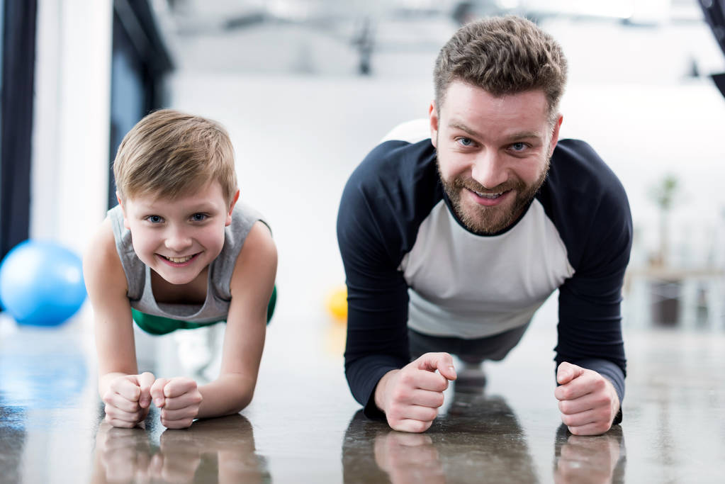 Hombre y niño haciendo ejercicio de tablón
 - Foto, imagen