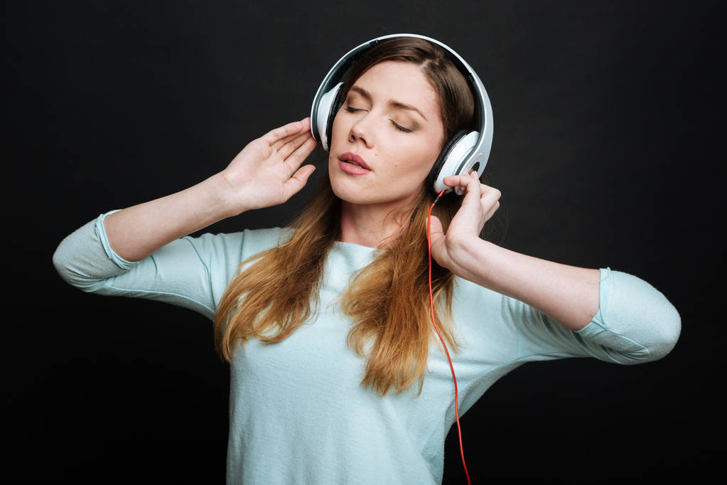 Elégedett fiatal nő élvezi a zenét a studio-ban - Fotó, kép