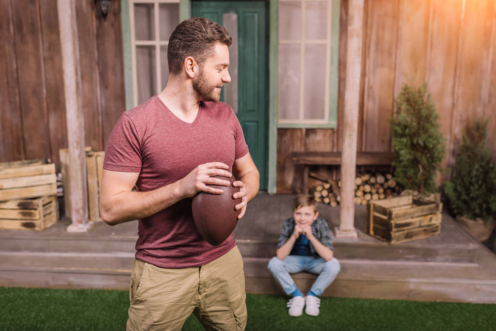 pai com filho brincando com bola no quintal
 - Foto, Imagem