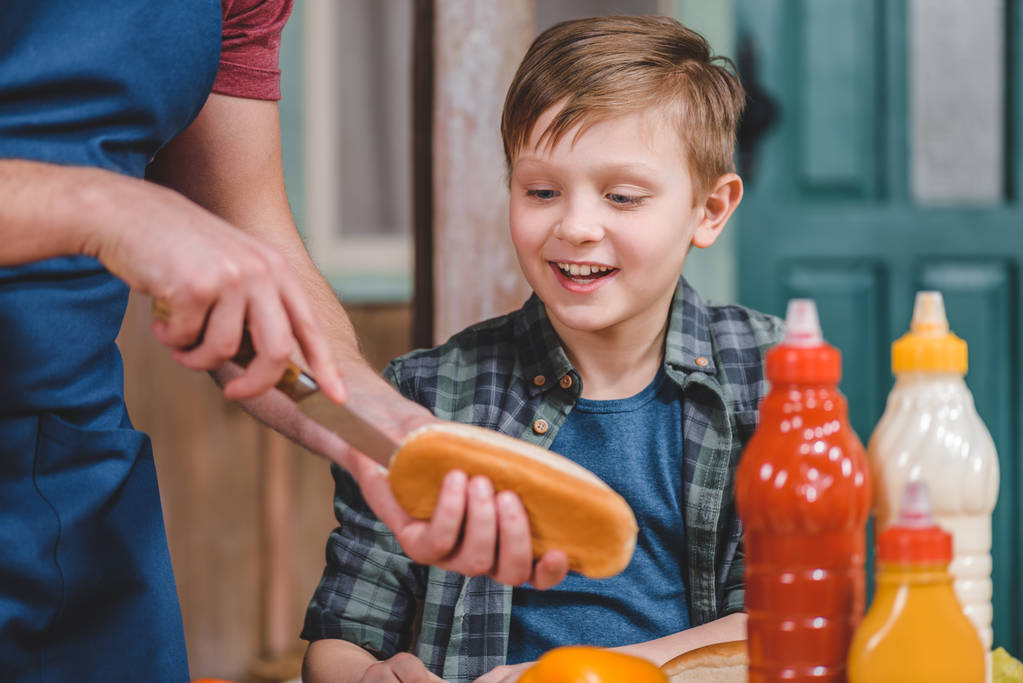 Padre e figlio che cucinano hot dog
  - Foto, immagini