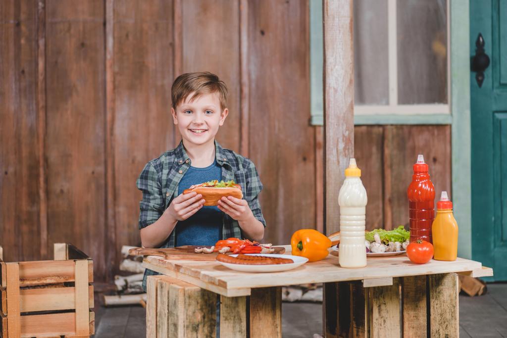 Çocuk holding sosisli sandviç  - Fotoğraf, Görsel
