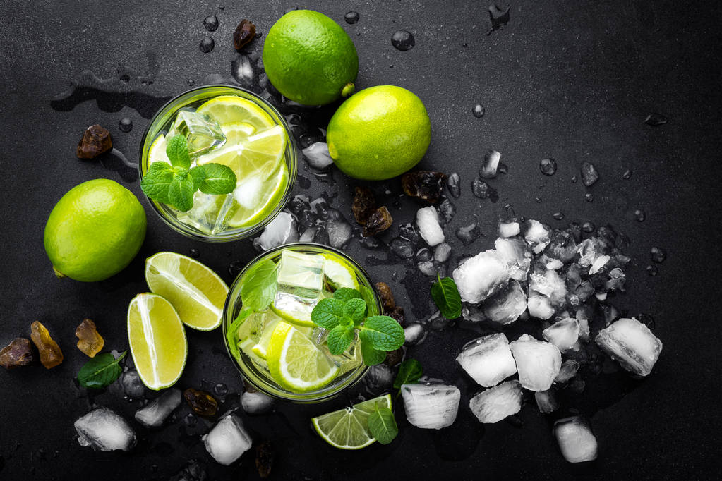 erfrischender Minzcocktail-Mojito mit Rum und Limette, Kaltgetränk oder Getränk mit Eis auf schwarzem Hintergrund, Draufsicht - Foto, Bild