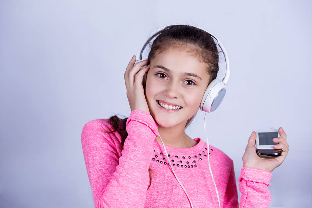 Sorrindo Menina gostando de música em fones de ouvido em casa relaxante
 - Foto, Imagem