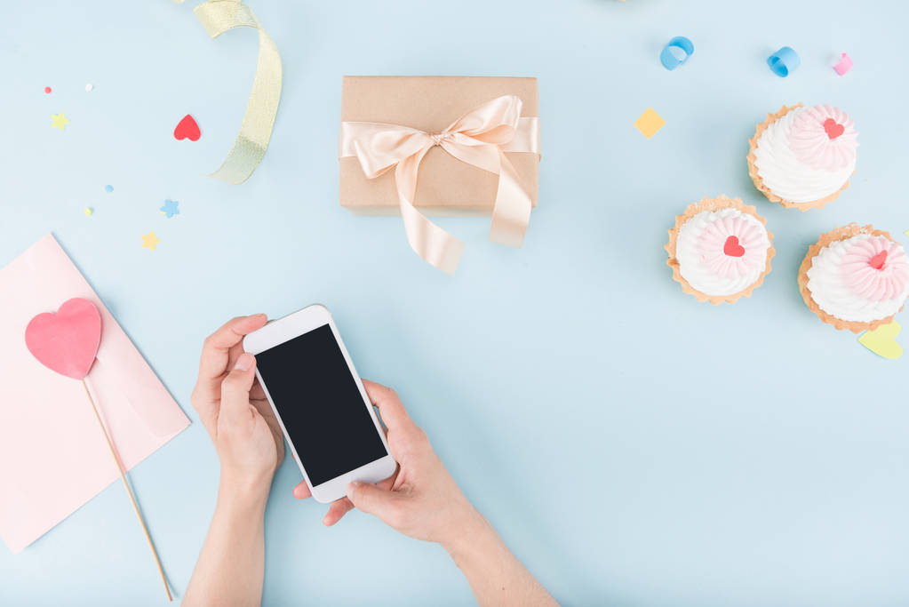 hands holding smartphone with cakes - Photo, Image