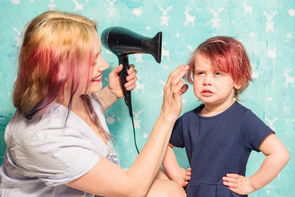 Mamãe seca o cabelo de sua filha
 - Foto, Imagem