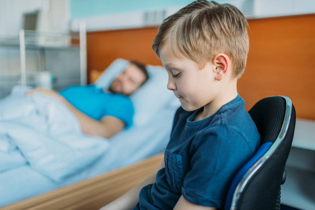 son sitting near sick father at ward - Photo, Image