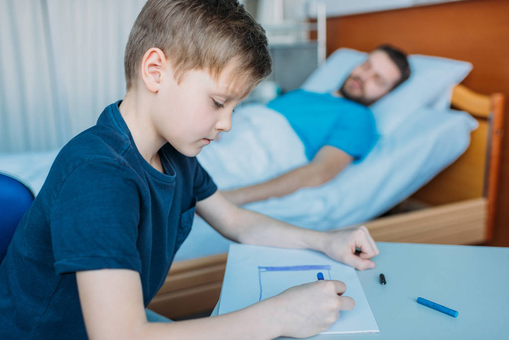 сын рисует, пока больной отец лежит
 - Фото, изображение