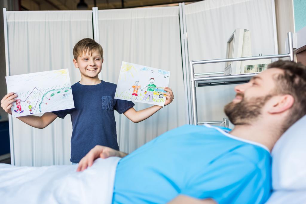 Sohn zeigt kranken Vater Zeichnungen - Foto, Bild