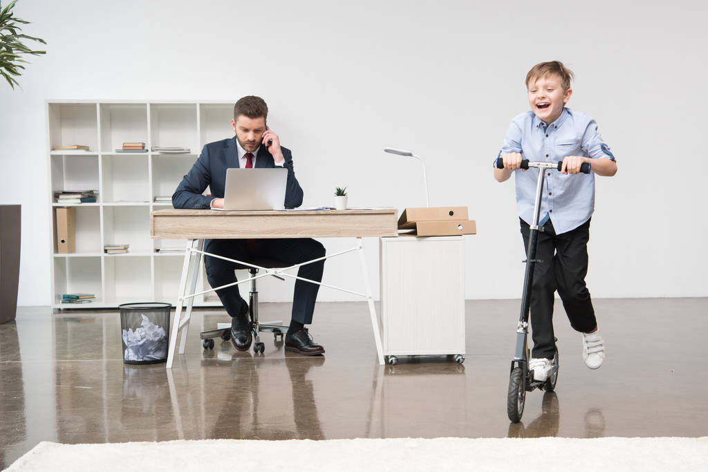 Onnellinen poika ratsastus skooter toimistossa
 - Valokuva, kuva