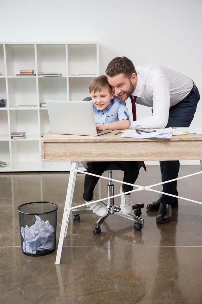 Empresário jogando no laptop com filho
 - Foto, Imagem