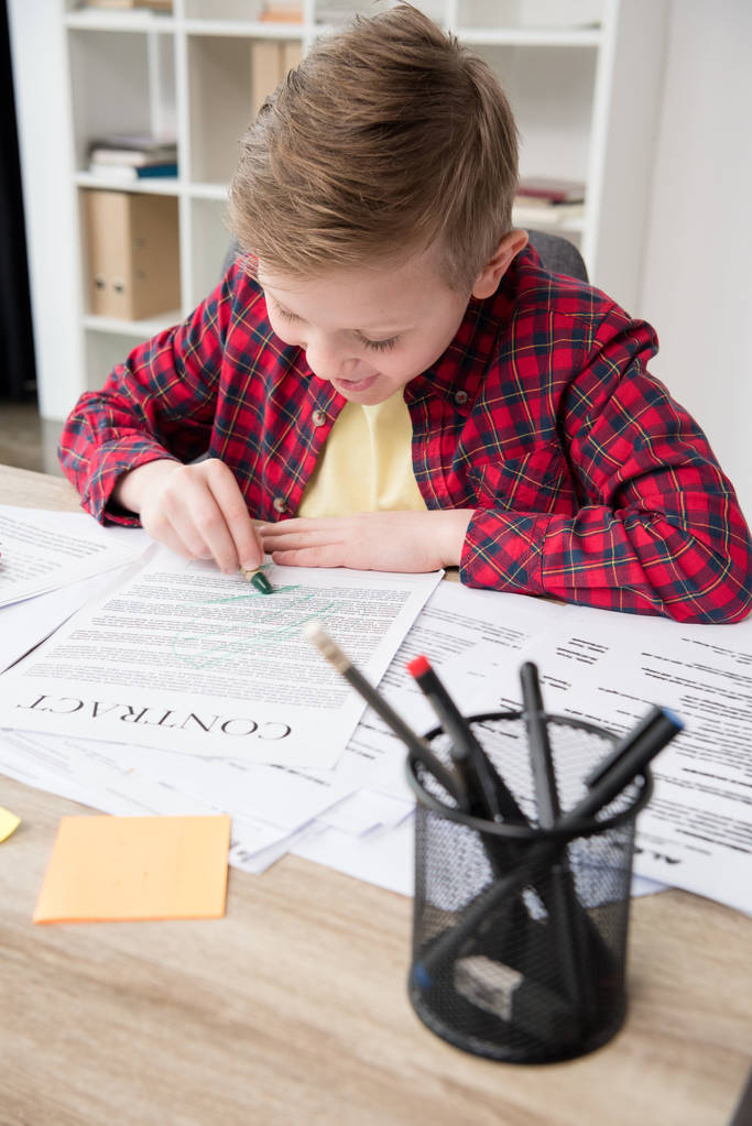 Неслухняний хлопчик малює на бізнес-паперах
 - Фото, зображення