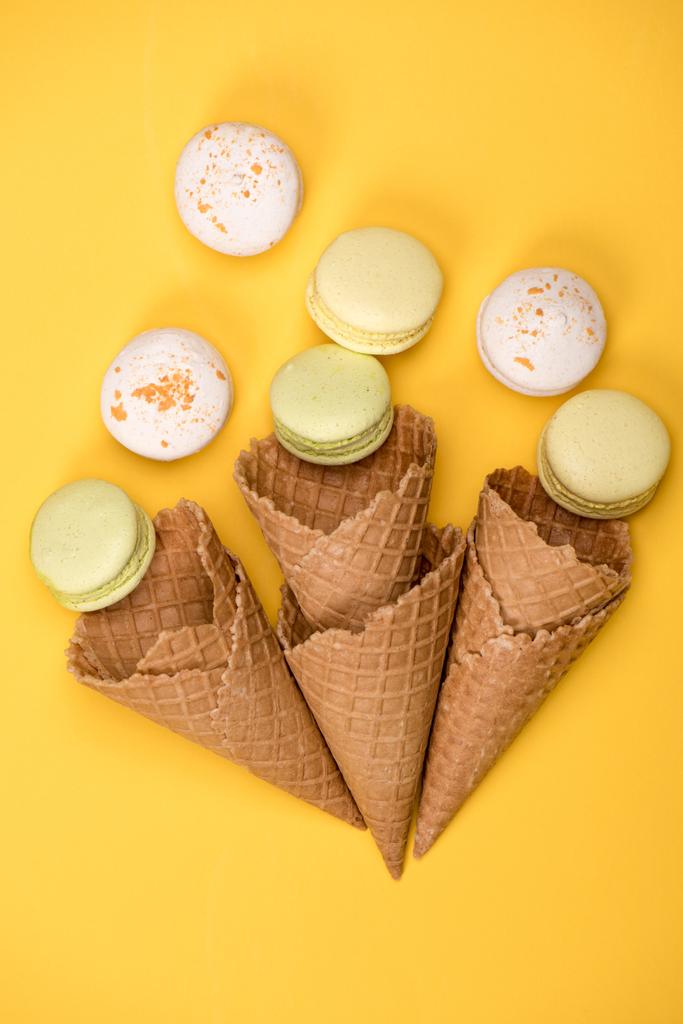 Gele en witte macarons in wafel kegels - Foto, afbeelding