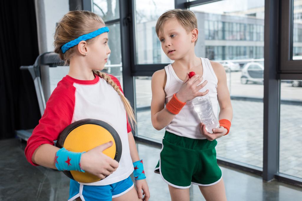 маленький хлопчик і дівчинка в спортивному одязі розмовляють
 - Фото, зображення