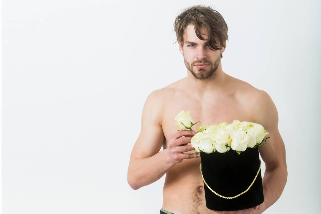 Barbudo sexy macho sosteniendo rosas en caja de regalo negro
 - Foto, imagen