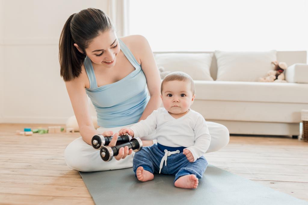 Femme avec bébé enfant utilisant des haltères
  - Photo, image