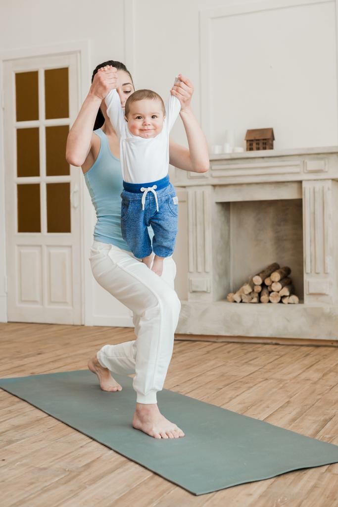 Мати з маленьким хлопчиком практикує йогу
  - Фото, зображення