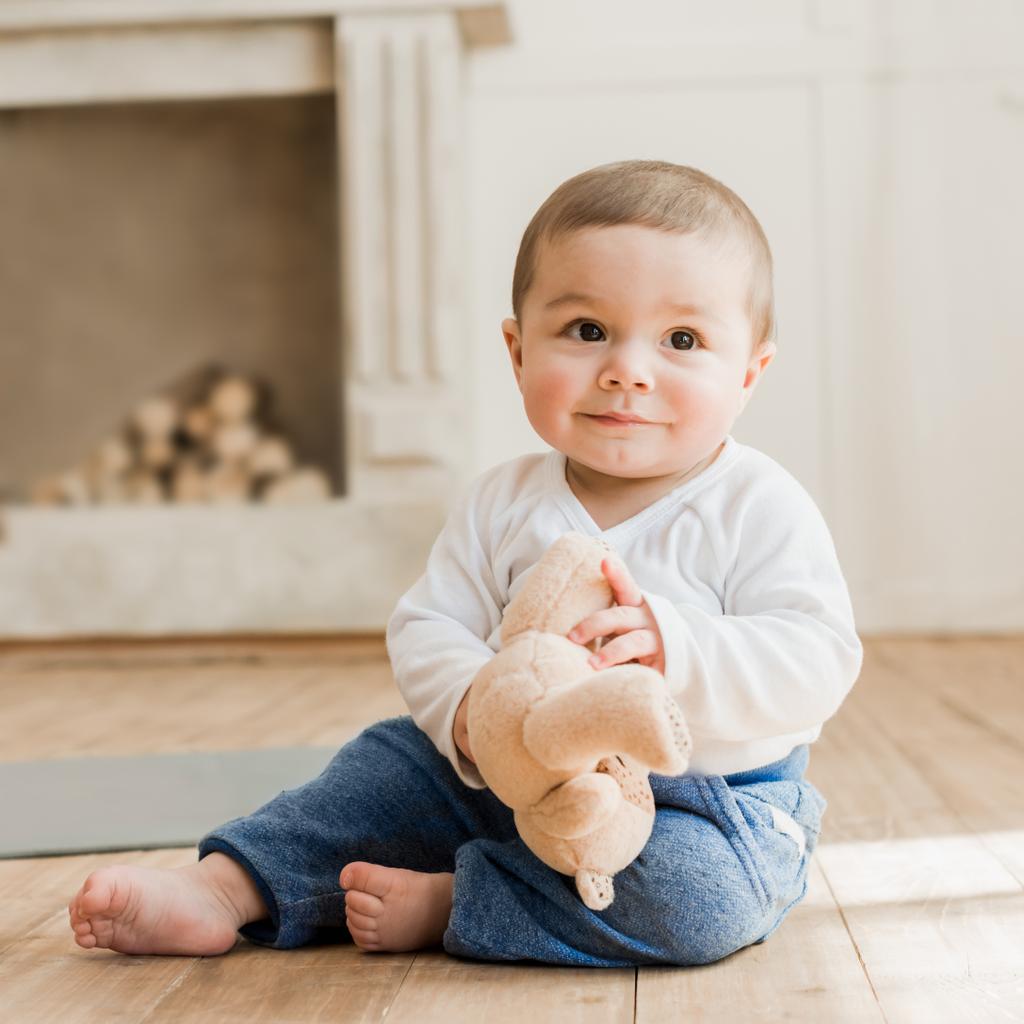 Oyuncak ayı ile oturan bebek boy gülümseyerek  - Fotoğraf, Görsel