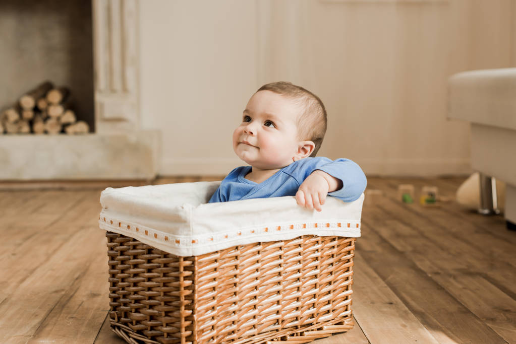 Chłopiec dziecko siedzi pleciony pudełko - Zdjęcie, obraz