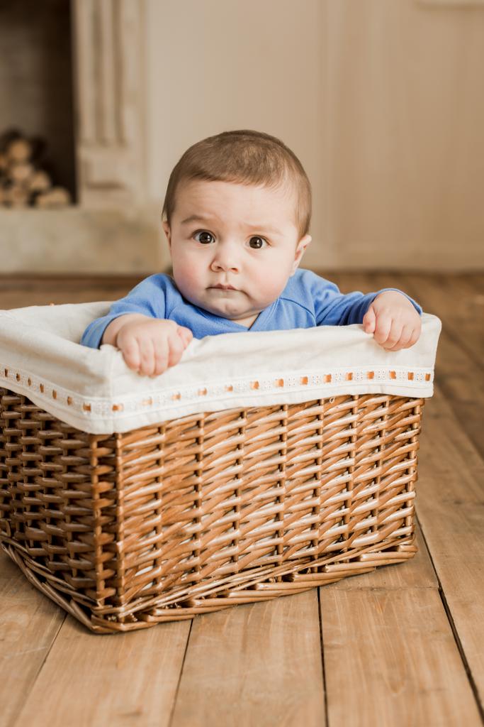 Niño sentado en caja trenzada
 - Foto, imagen