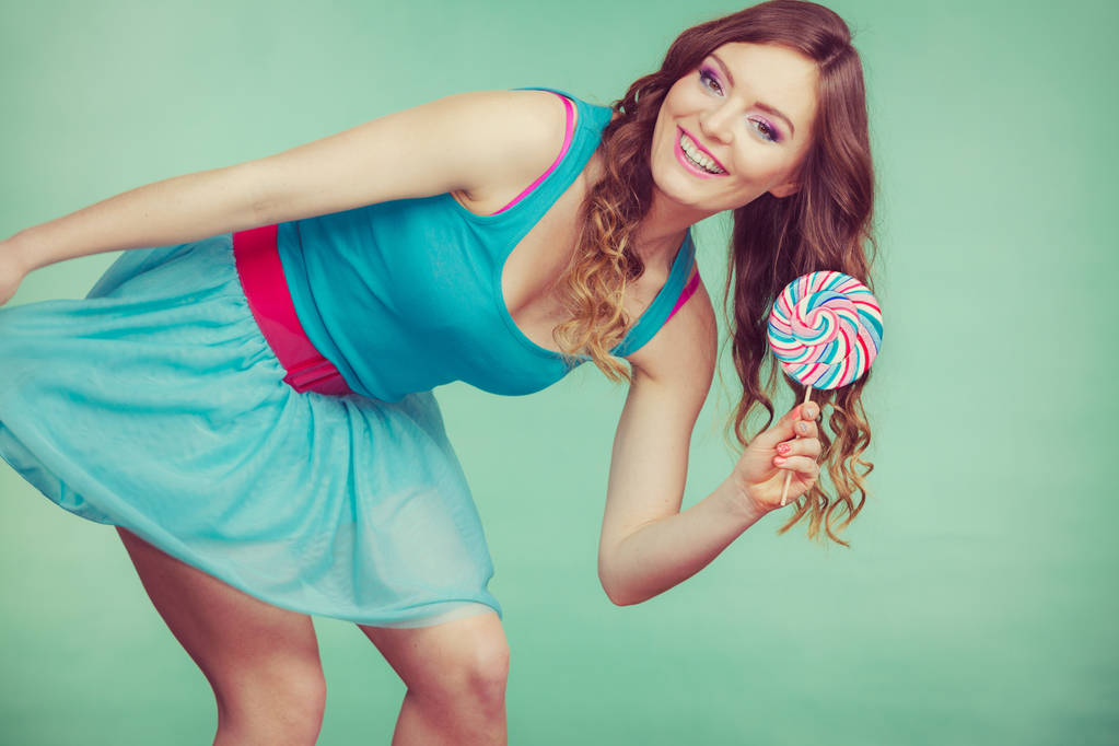 Menina sorridente com doces pirulito em teal
 - Foto, Imagem