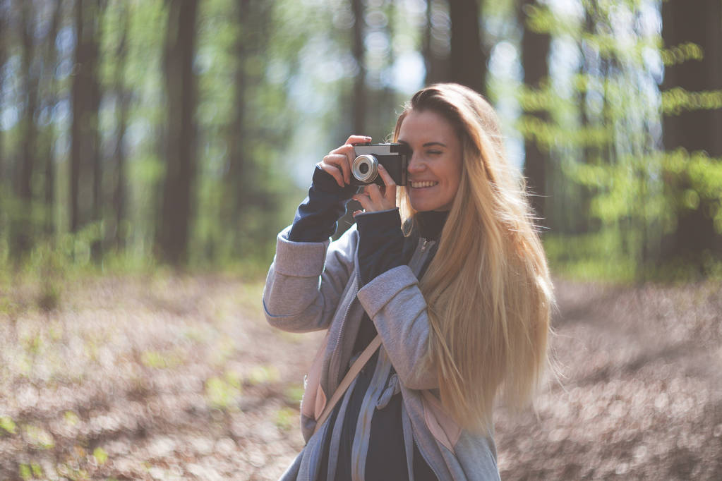 Женщина в парке фотографирует на ретро-камеру
 - Фото, изображение