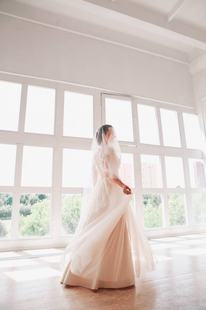 Portret van de mooie bruid binnen. Mode bruid meisje in prachtige trouwjurk in studio - Foto, afbeelding