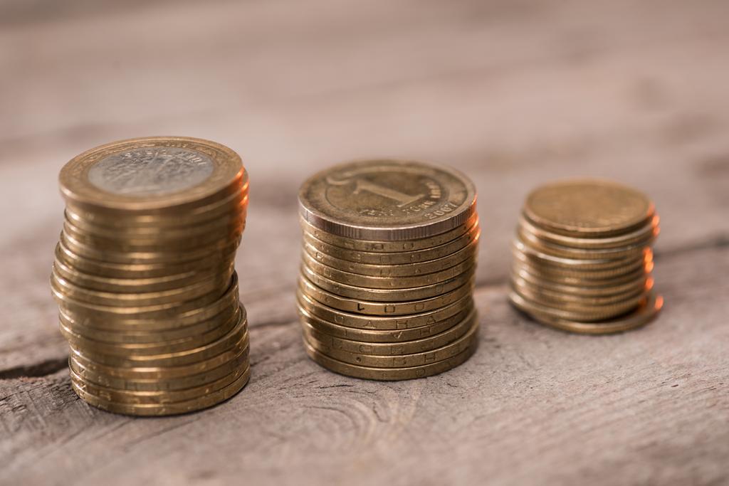 Пачки монет на деревянном столе
 - Фото, изображение