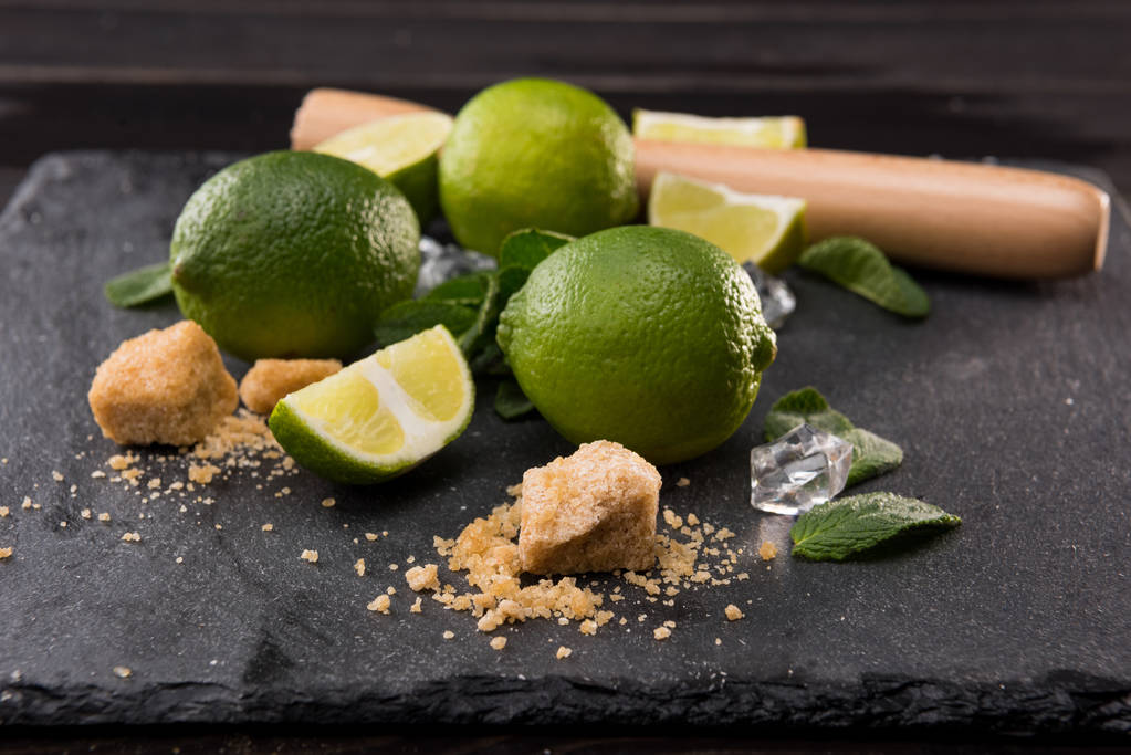 lime slices with sugar and wooden squeezer - Photo, Image