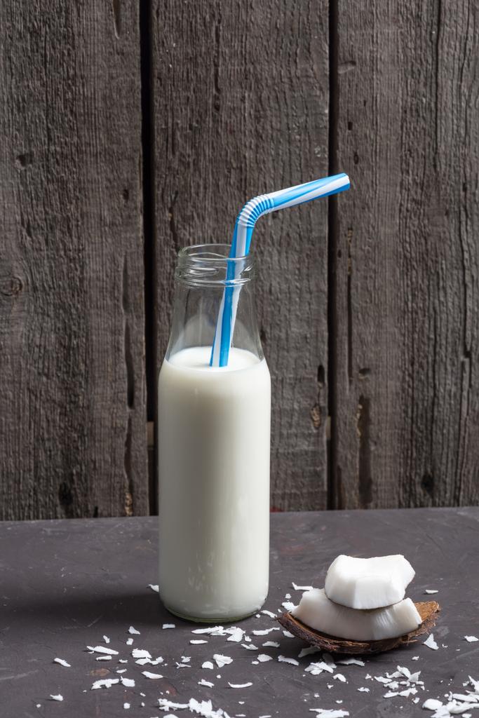 coconut pieces with flakes and milk in bottle  - Photo, Image