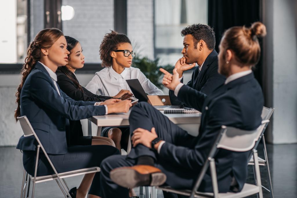 Коллеги в формальной одежде спорят на деловой встрече
 - Фото, изображение