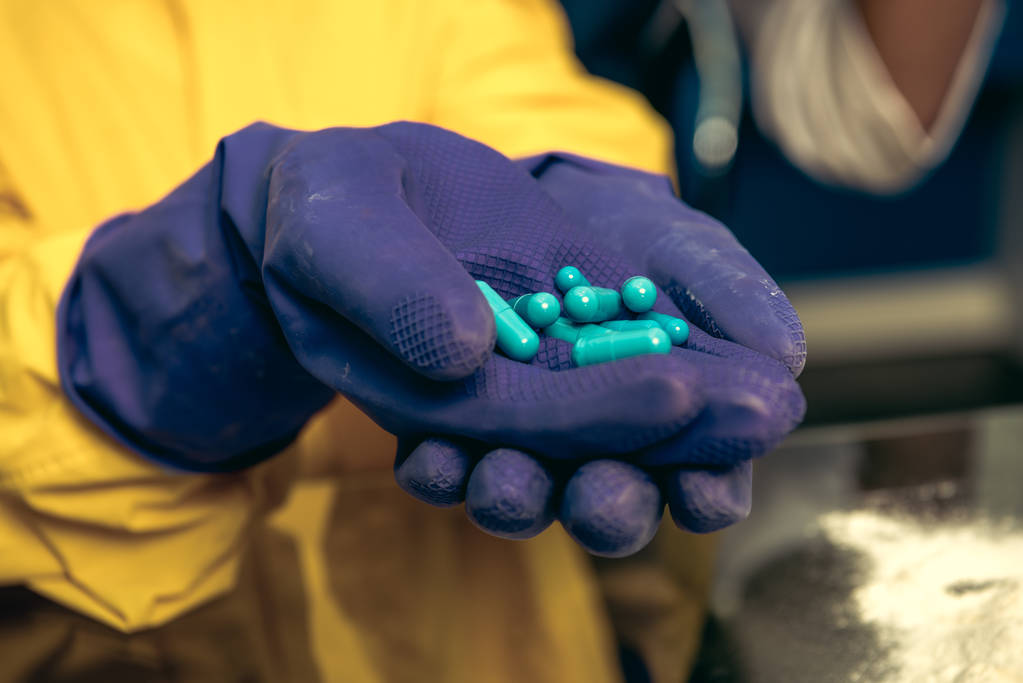 Hände in Gummihandschuhen mit Tabletten - Foto, Bild