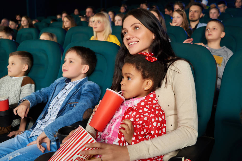 Дети с родителями, наслаждающиеся совместным кино в кинотеатре
 - Фото, изображение