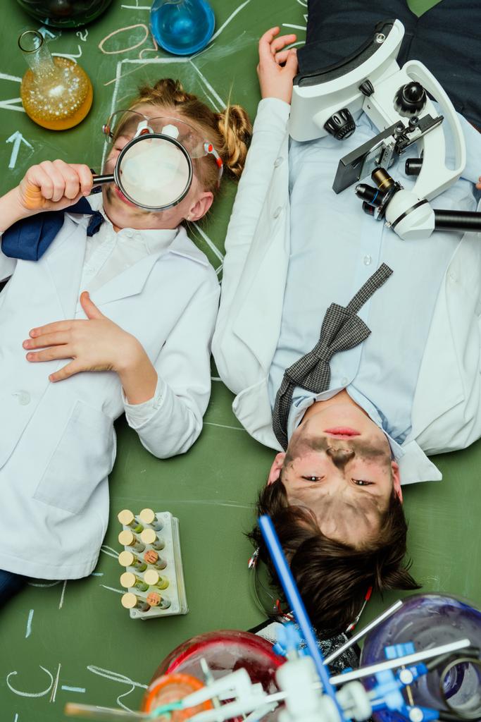 děti v laboratorní pláště ležící na tabuli - Fotografie, Obrázek