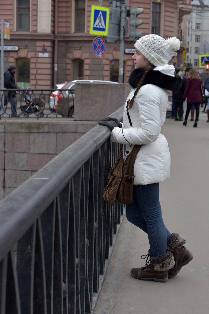 Teen girl in a white coat and hat on the waterfront. - Photo, Image