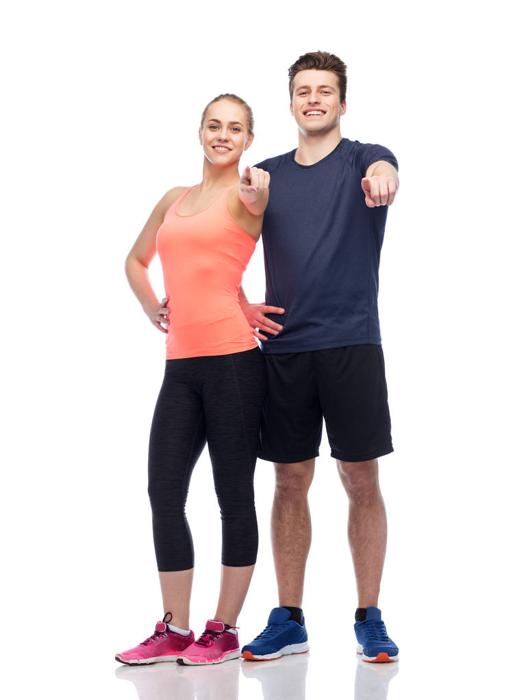 happy sportive man and woman pointing finger - Photo, Image