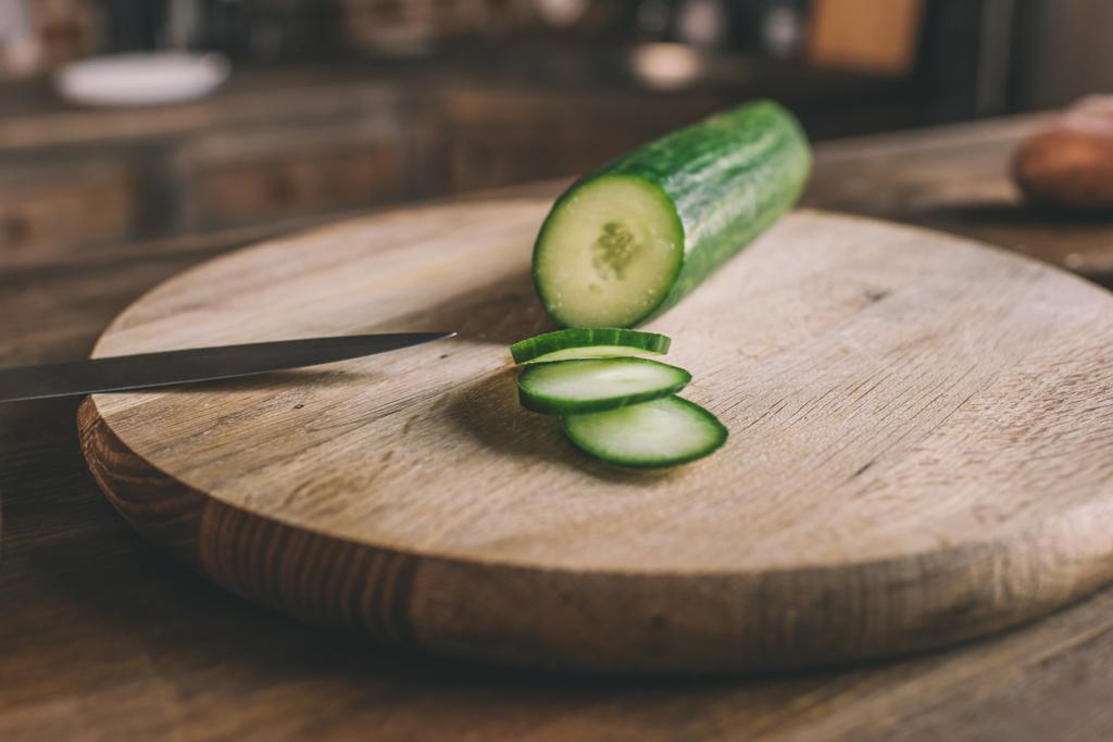 gehakte komkommer op snijplank  - Foto, afbeelding
