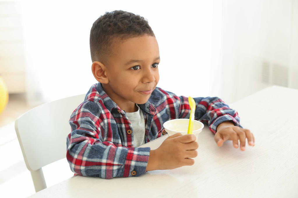 Afro-americano menino comendo iogurte
 - Foto, Imagem