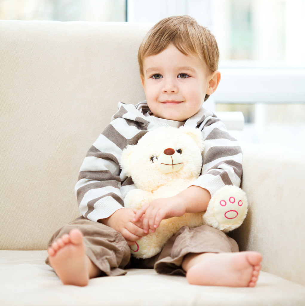 Маленький хлопчик тримає свого плюшевого ведмедя
 - Фото, зображення
