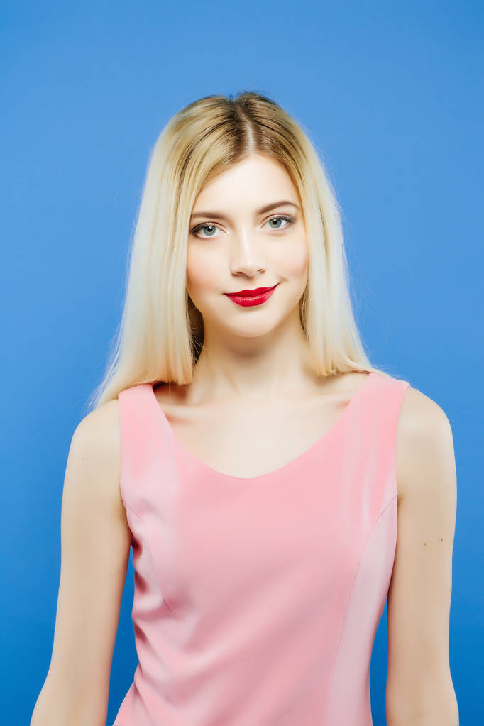 Geweldige blonde vrouw met professionele make-up in de Studio. Portret van mooi meisje op blauwe achtergrond. - Foto, afbeelding